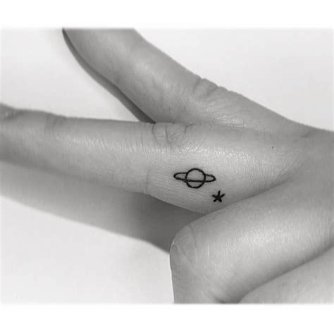 Tiny Saturn And Star Tattoo Located On The Finger