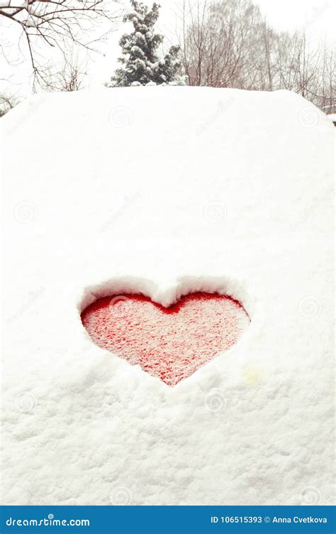 Valentine Love Red Heart Shape In Snow On Red Car Hood Stock Image