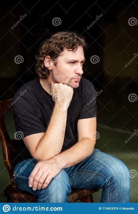 Portrait Of Brooding Man Sitting On Chair Stock Photo Image Of