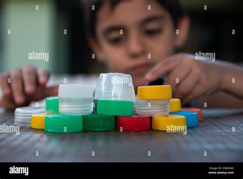 Retrato De Un Niño Jugando Con Tapas De Soda Recicladas Fotografía De Stock Alamy