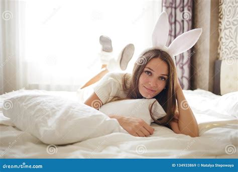 Lovely Brunette Girl With Bunny Ears On Her Head And Lying With Coffee