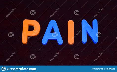 Pain Word Written With Different Colored Letter Blocks On A Dark