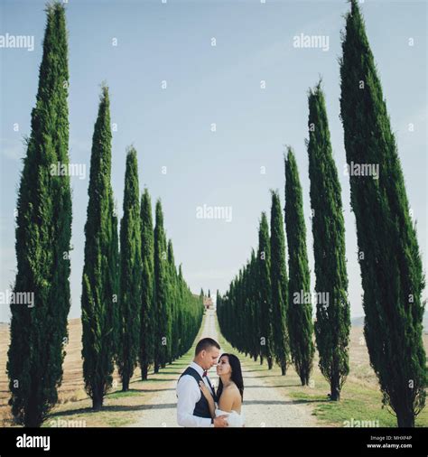 happy stylish smiling couple walking and kissing in tuscany italy on