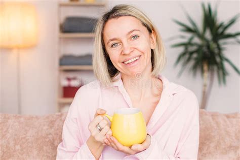 adult woman sitting on the sofa at home and having a cup of coffee stock image image of