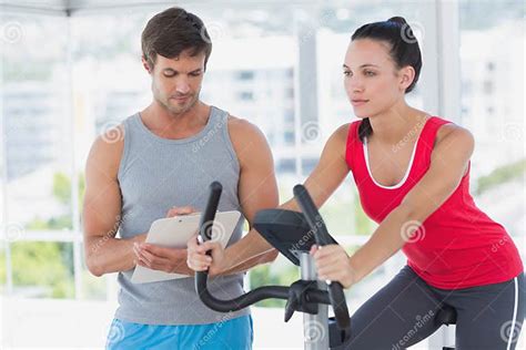 Woman With Male Instructor Working Out At Spinning Class Stock Image