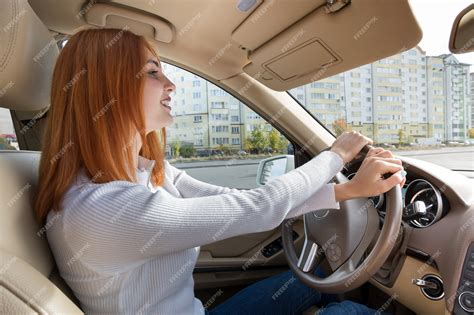Premium Photo Young Redhead Woman Driver Behind A Wheel Driving A Car