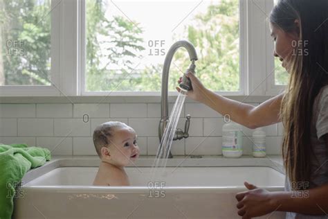 Young Girl Giving Baby A Bath In Kitchen Sink Stock Photo Offset