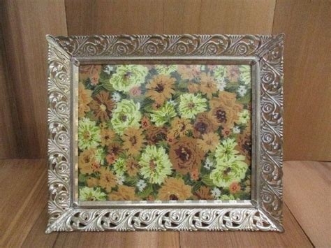 An Ornate Silver Frame With Sunflowers Painted On The Wall Behind It Is