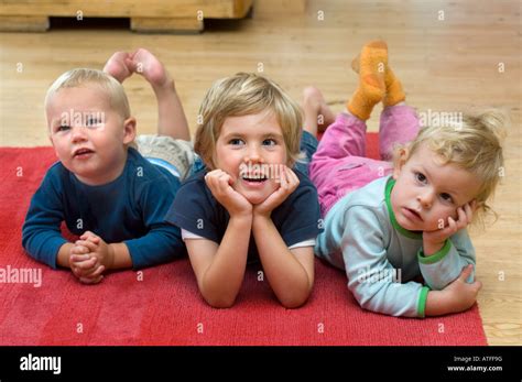 Three Children Lying On The Floor Stock Photo Alamy