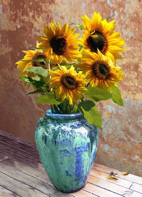 A Blue Vase Filled With Yellow Sunflowers On Top Of A Wooden Table