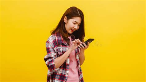 Smiling Adorable Asian Female Using Phone With Positive Expression