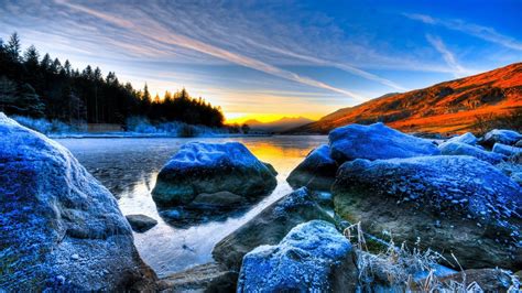 Frozen Rocks On River Landscape View Of Trees In Sunrise Background