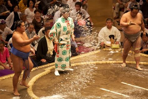 A sumo wrestler throwing salt into the dohyō ring to purify it Sumo wrestler Japan History