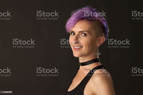 Studio Portrait Of A 30 Year Old Woman With Purple Iroquois On A Black