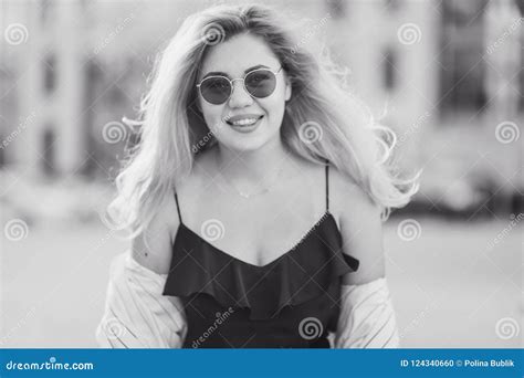 Beautiful Young Blonde Girl In Sunglasses With Puffy Lips And Feminine Body Posing On The Street
