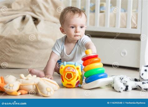 Adorable Baby Boy Playing On Floor With Colorful Toy Cars Towers And