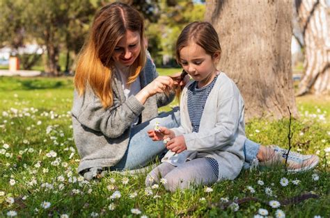 Madre E Hija Mirando Flores Foto Gratis