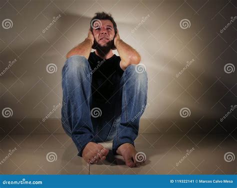 Young Desperate And Depressed Man Crying Alone Sitting At Home Floor In