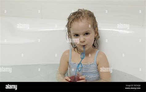 Attractive Four Years Old Girl Takes A Bath In Swimwear And Drinking A Cocktail Relax Wet Hair