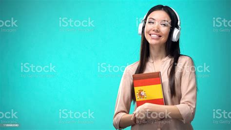 Girl Listening Spanish Audio Lessons In Headset Book In Hands