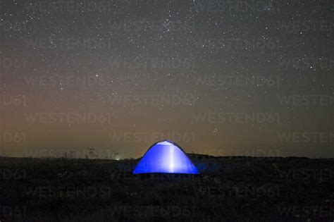 Glowing Tent Under Starry Night Sky Stock Photo