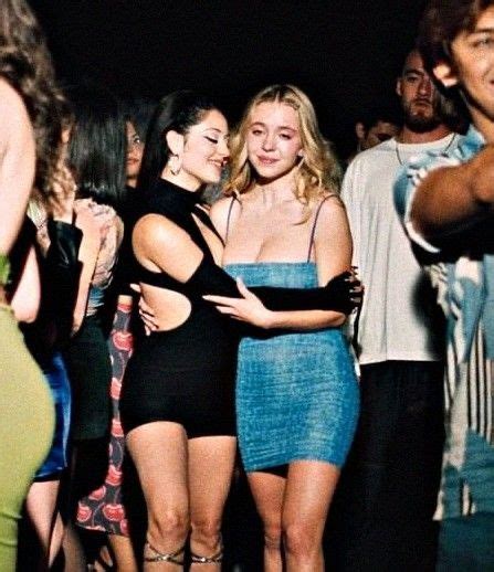 Two Women Hugging Each Other In Front Of A Group Of People At A Club Or