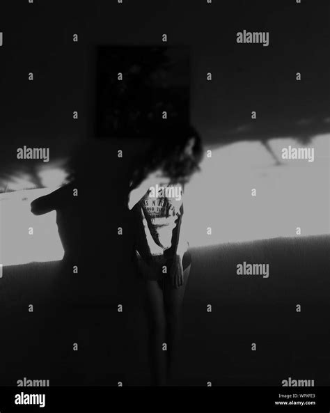 Femme debout contre le mur noir Banque de photographies et dimages à