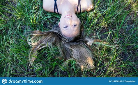 Portrait Young Blonde Woman Laying In The Grass With Long Hair And Blue