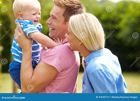 Parents Hugging Young Son In Garden Stock Photo Image Of Toddler