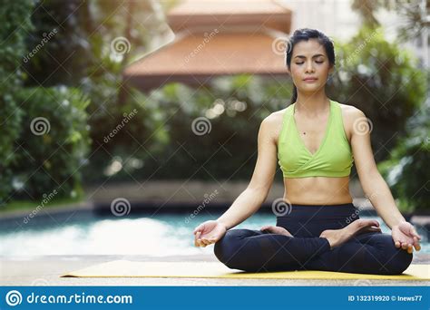 Healthy And Relaxation Concept Woman Practicing Yoga Pose Meditates In The Lotus Position