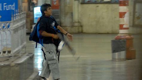 A Photo Of Kasab Striding Through Mumbais Main Train Station With An