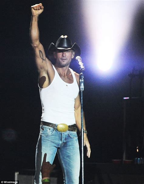 they came out of nowhere country music star tim mcgraw reveals his bulging biceps as he takes