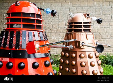 Two Daleks From The Bbc Tv Series A Red Mark Three Dalek Next To A New