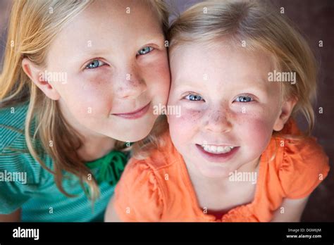 A Portrait Of Two Sisters Smiling Two Young Girls With Blue Eyes