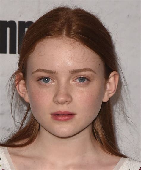 a close up of a person wearing a white shirt and red hair with blue eyes