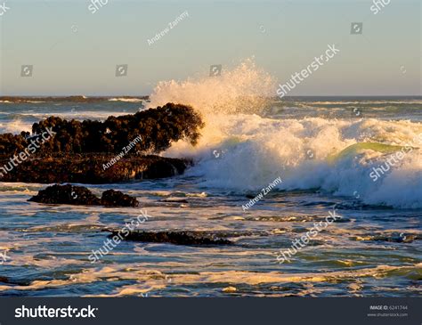 Waves Crashing Against The Rocks At Sunset Stock Photo 6241744