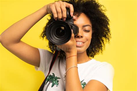 Creative Woman Photographer Takes Photos Isolated On Yellow Stock