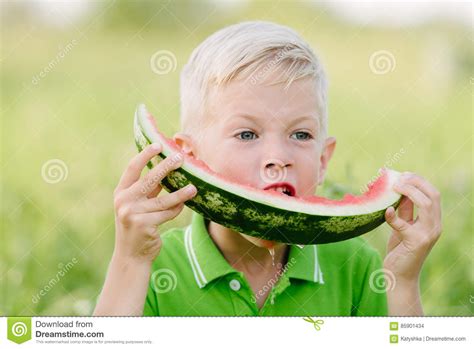 Funny Little Toddler Boy With Blond Hairs Eating Watermelon Outdoors