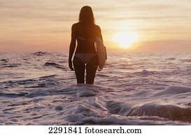 Silhouette Rear View Of Nude Caucasian Woman Standing Saluting The Sun