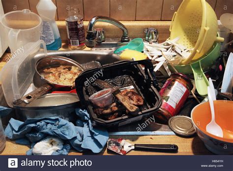 Dirty Dishes With Old Food Piled In A Sink In A Messy Kitchen Stock