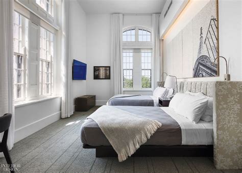 Two Beds Sitting Next To Each Other In A Room With White Walls And Flooring