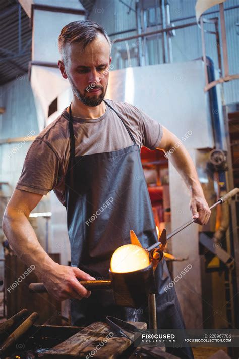 Glassblower Forming And Shaping A Molten Glass At Glassblowing Factory — Workstation