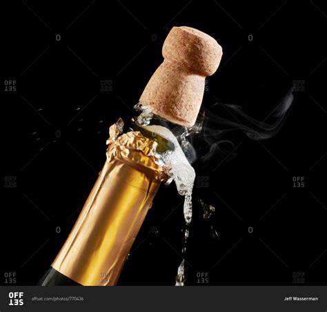 Closeup Of Champagne Cork Popping Out Of Bottle Stock Photo Offset
