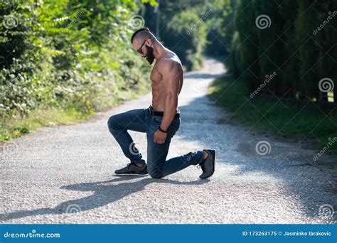 Portrait Of A Model Man Kneeling Outdoors Stock Image Image Of