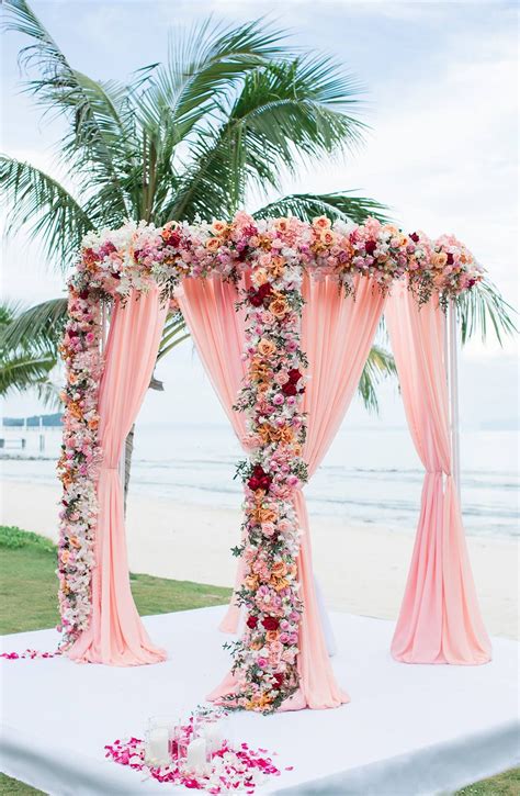 Luxuriously Decorated Pink Arch With Blush Drapes And Blooms Of Orange