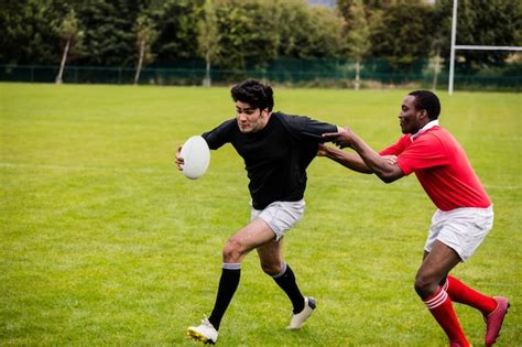 Premium Photo Rugby Players Tackling During Game