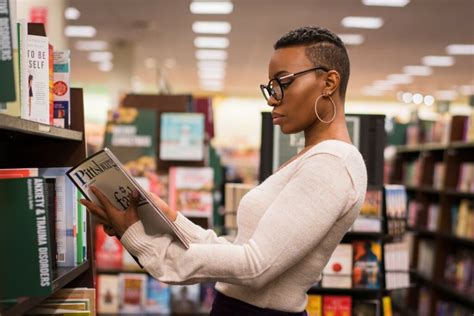 Black Woman Reading A Book In A Bookstore Or Library State Innovation