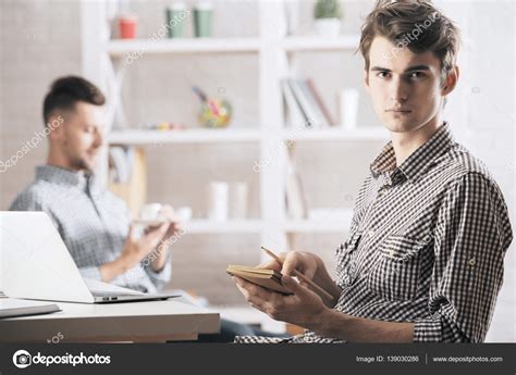 Handsome Man Writing In Notepad Stock Photo By Peshkova