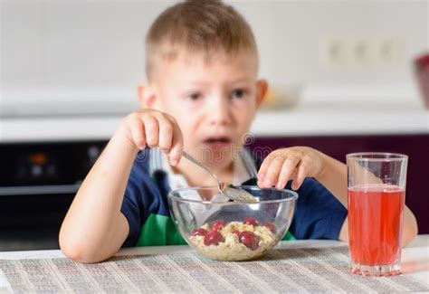Boy Eating Cherries Off Top Of Cereal At Breakfast Stock Image Image