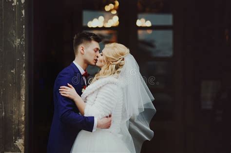 Handsome Newlywed Groom Kissing Happy Bride Outside Church After Stock